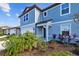 Two-story light blue house with landscaping and driveway at 11628 Middle Fork Way, Parrish, FL 34219