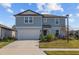 Two story house, gray siding, attached garage, and front yard at 11628 Middle Fork Way, Parrish, FL 34219