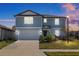 Two-story house with gray siding, attached garage, and landscaping at 11628 Middle Fork Way, Parrish, FL 34219