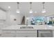 Modern kitchen island with white cabinets, stainless steel sink and dishwasher at 11628 Middle Fork Way, Parrish, FL 34219