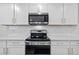 Stainless steel range and microwave in a modern white kitchen at 11628 Middle Fork Way, Parrish, FL 34219