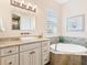Bathroom with soaking tub, granite vanity, and updated fixtures at 12334 Baypointe Ter, Cortez, FL 34215