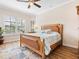 Spacious bedroom with a king-size bed, wood floors, and plantation shutters at 12334 Baypointe Ter, Cortez, FL 34215