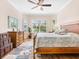 Bright bedroom with king bed, wood floors, and large windows with shutters at 12334 Baypointe Ter, Cortez, FL 34215