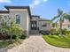 Front entrance with paver driveway and lush landscaping at 12334 Baypointe Ter, Cortez, FL 34215