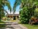 Rustic farm stand with a tractor, surrounded by lush tropical foliage at 12334 Baypointe Ter, Cortez, FL 34215