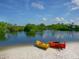 Two kayaks on a sandy beach overlooking a calm body of water at 12334 Baypointe Ter, Cortez, FL 34215