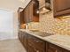 Kitchen boasting granite countertops, dark wood cabinets, and a stylish backsplash at 12334 Baypointe Ter, Cortez, FL 34215