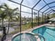 Enclosed pool and spa with water feature; canal view at 12334 Baypointe Ter, Cortez, FL 34215