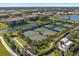 An aerial view of tennis and bocce ball courts along with beautiful landscaping and water features at 12410 Osorio Ct # 101, Sarasota, FL 34238