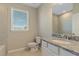 Bright bathroom featuring granite countertops, sink, toilet, and a window at 12410 Osorio Ct # 101, Sarasota, FL 34238
