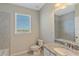 Bright bathroom featuring granite countertop, tiled shower, and a large window for natural light at 12410 Osorio Ct # 101, Sarasota, FL 34238