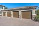 Row of garages with brown doors and stone accents, set on a paver driveway at 12410 Osorio Ct # 101, Sarasota, FL 34238