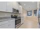 Well-equipped kitchen with stainless steel appliances, white cabinets, and granite countertops at 12410 Osorio Ct # 101, Sarasota, FL 34238