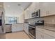 Bright kitchen with stainless steel appliances, granite countertops, and white cabinets at 12410 Osorio Ct # 101, Sarasota, FL 34238