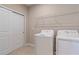 Functional laundry room equipped with washer, dryer, storage shelf and sliding door at 12410 Osorio Ct # 101, Sarasota, FL 34238
