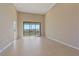 Spacious living room featuring tile flooring, high ceilings, and a sliding glass door at 12410 Osorio Ct # 101, Sarasota, FL 34238