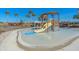 Fun splash pad area for with slide and play structure, surrounded by lush landscaping at 12410 Osorio Ct # 101, Sarasota, FL 34238