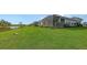 Landscaped backyard, featuring a pond view and home exterior at 12681 Palatka Dr, Venice, FL 34293