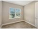 Bright bedroom with wood-look tile flooring and a large window at 12681 Palatka Dr, Venice, FL 34293