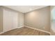 Spacious bedroom with wood-look floors and double doors to closet at 12681 Palatka Dr, Venice, FL 34293
