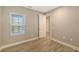 Well-lit bedroom with wood-look tile floor and window with blinds at 12681 Palatka Dr, Venice, FL 34293