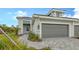 Single-story home with gray garage door and paved driveway at 12681 Palatka Dr, Venice, FL 34293