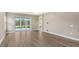 Bright main bedroom with wood-look tile flooring and sliding glass doors to a patio at 12681 Palatka Dr, Venice, FL 34293