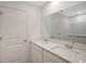 Double vanity bathroom with a large mirror and white cabinets at 13009 Cedar Elm Lane, Parrish, FL 34219