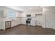 Modern kitchen with white cabinets, stainless steel appliances, and laminate floors at 13009 Cedar Elm Lane, Parrish, FL 34219