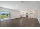Open living area with kitchen, view of backyard, and laminate flooring at 13009 Cedar Elm Lane, Parrish, FL 34219