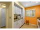 Orange-walled kitchen with white cabinets and granite counters at 1519 Pelican Point Dr # 187, Sarasota, FL 34231