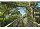 Picturesque walking trail bordered by mature trees, leading towards scenic water views at 1601 Bayhouse Point Dr # Ba101, Sarasota, FL 34231