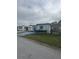 White manufactured home with blue accents and a small, grassy yard at 1660 Old Elm St, Sarasota, FL 34234
