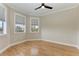 Neutral bedroom with ceiling fan, hardwood floors and two bright windows at 1825 Bayshore Dr, Terra Ceia, FL 34250