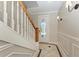 Elegant entryway with tiled floor design, wooden stairway, and stylish sconce lighting at 1825 Bayshore Dr, Terra Ceia, FL 34250