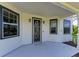 Inviting front porch features a secure front door and multiple windows for ample natural light at 1825 Bayshore Dr, Terra Ceia, FL 34250