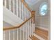 Elegant staircase with wood railing and white balusters at 1825 Bayshore Dr, Terra Ceia, FL 34250