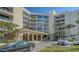 Condo building exterior featuring attractive landscaping and ample parking at 2110 Harbourside Dr # 522, Longboat Key, FL 34228