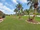 Landscaped backyard with lush lawn and palm trees at 25067 Palisade Rd, Punta Gorda, FL 33983