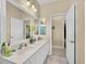 Double vanity bathroom with large mirror and access to hallway at 25067 Palisade Rd, Punta Gorda, FL 33983