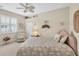 Comfortable bedroom with a ceiling fan, recliner, and window shutters at 25067 Palisade Rd, Punta Gorda, FL 33983