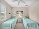 Twin bedroom with light teal bedding and ceiling fan at 25067 Palisade Rd, Punta Gorda, FL 33983