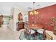 Formal dining room with a wood table, chandelier, and red accent wall at 25067 Palisade Rd, Punta Gorda, FL 33983