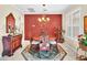 Elegant dining room featuring a round table and red wall at 25067 Palisade Rd, Punta Gorda, FL 33983
