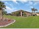 Tan house exterior with a screened patio and manicured lawn at 25067 Palisade Rd, Punta Gorda, FL 33983