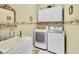 Laundry room with washer, dryer, sink, and overhead cabinets at 25067 Palisade Rd, Punta Gorda, FL 33983
