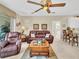 Bright living room featuring leather furniture, a coffee table and access to kitchen at 25067 Palisade Rd, Punta Gorda, FL 33983