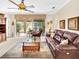 Spacious living room with leather furniture and sliding glass doors leading to backyard at 25067 Palisade Rd, Punta Gorda, FL 33983