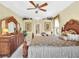 Elegant main bedroom with a king-size bed and ornate wooden furniture at 25067 Palisade Rd, Punta Gorda, FL 33983